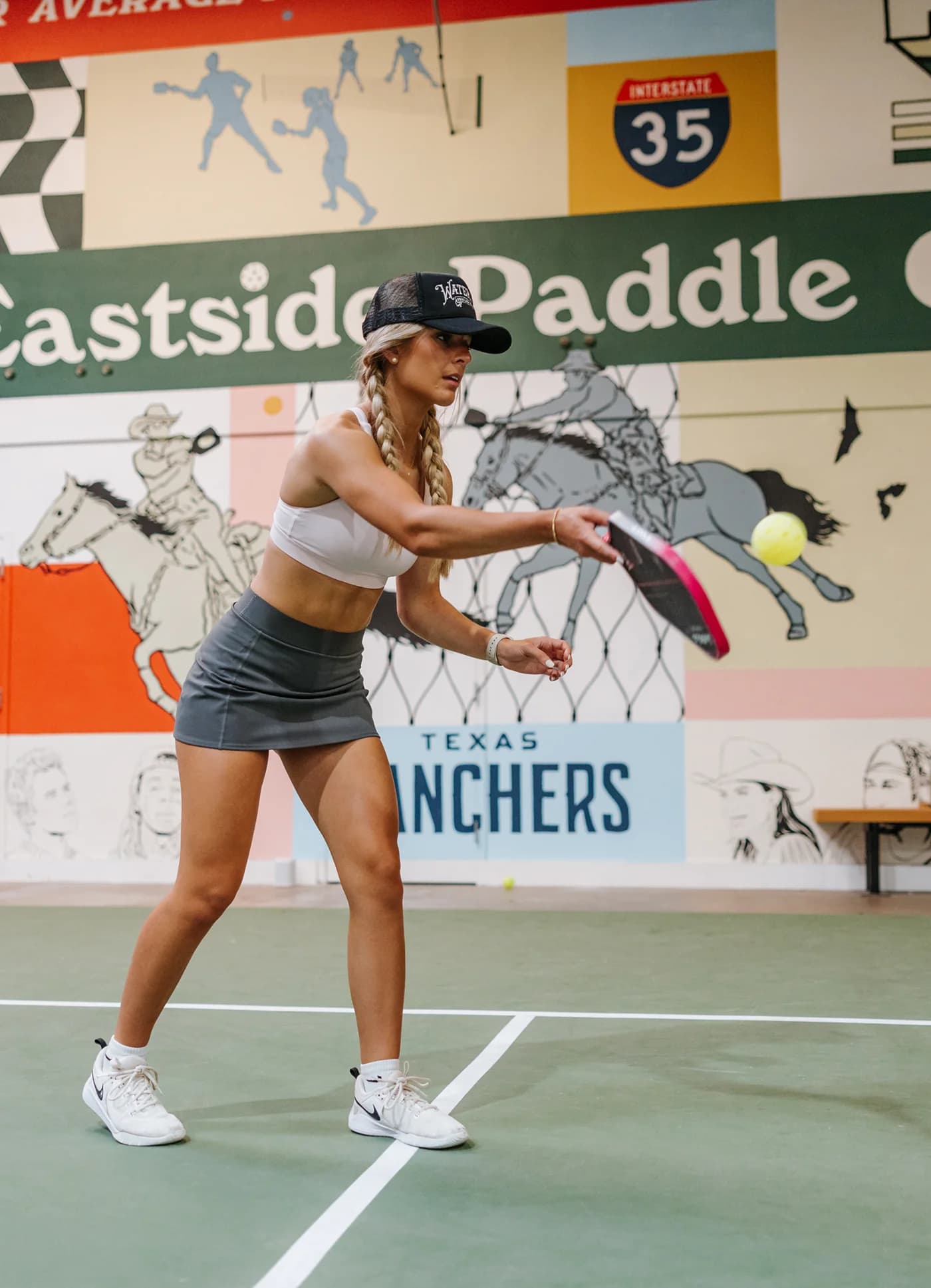 Sage & Paddle player serving on indoor court